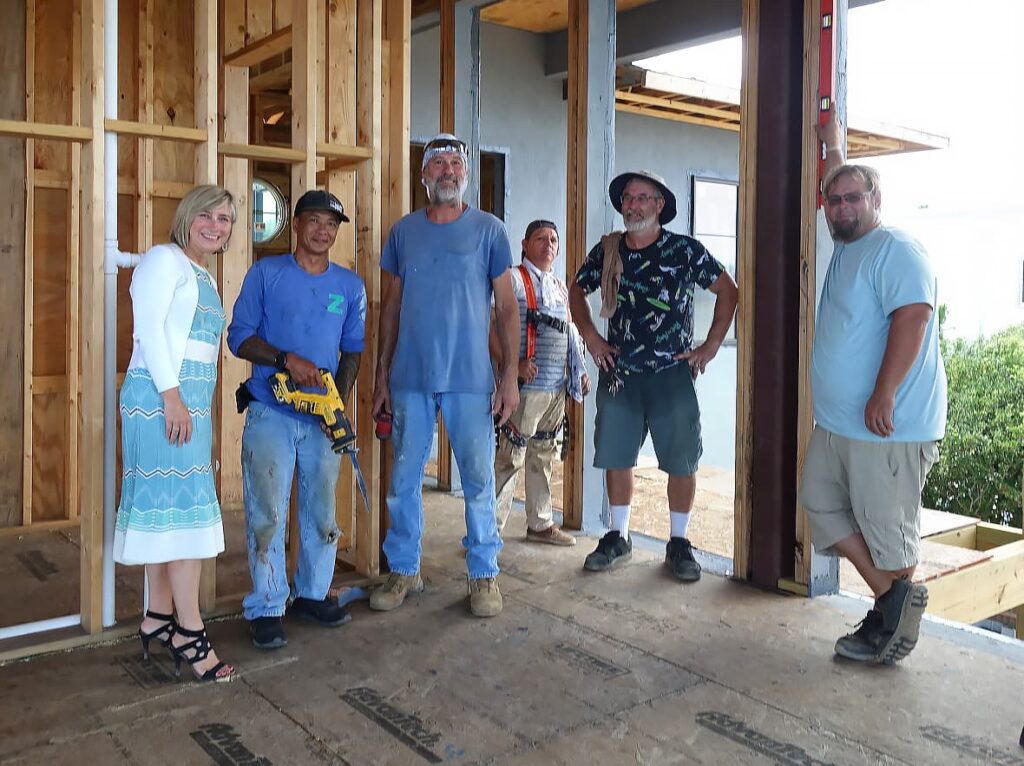 Image of 6 people standing in a home that is under construction